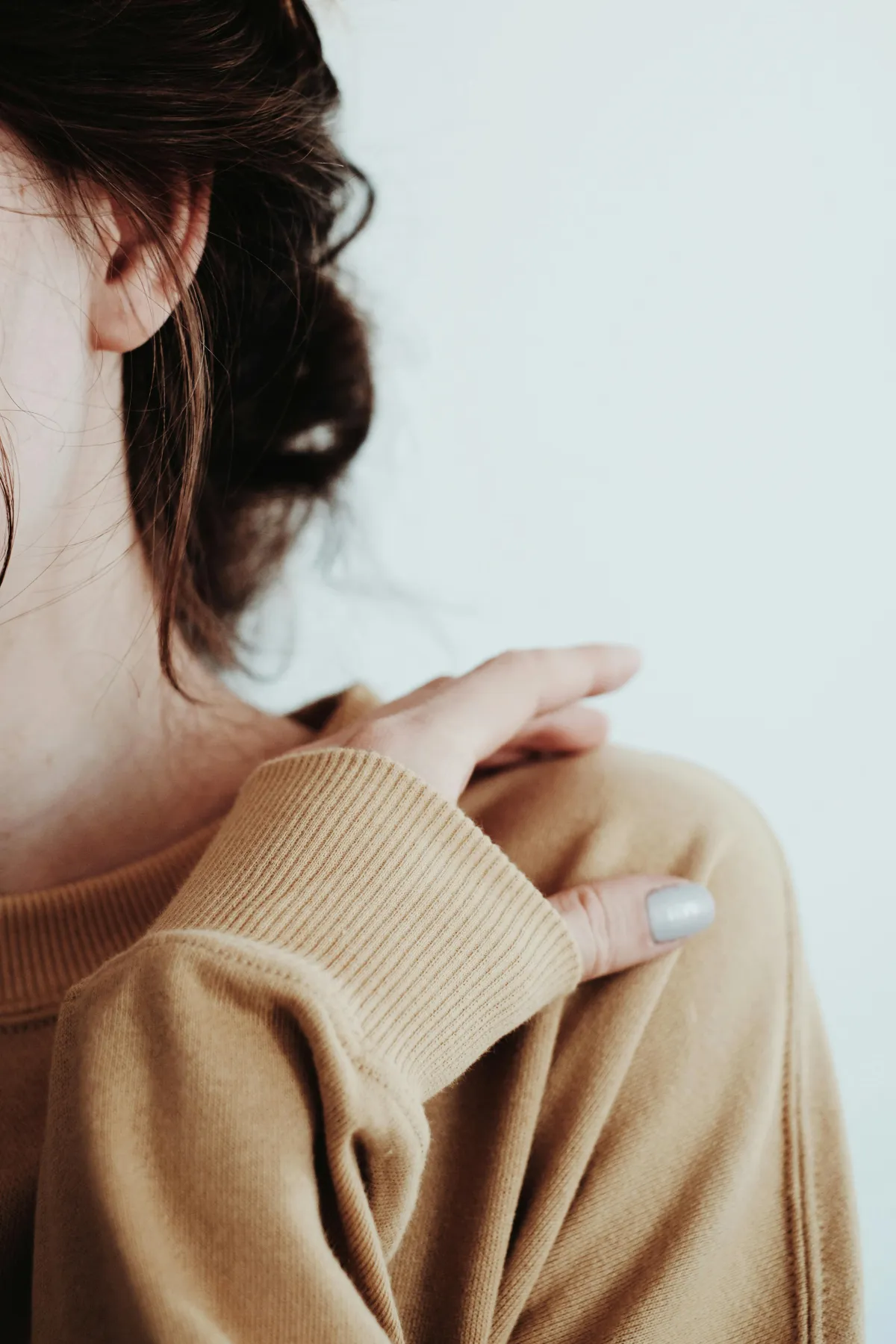 A person resting a hand on their shoulder